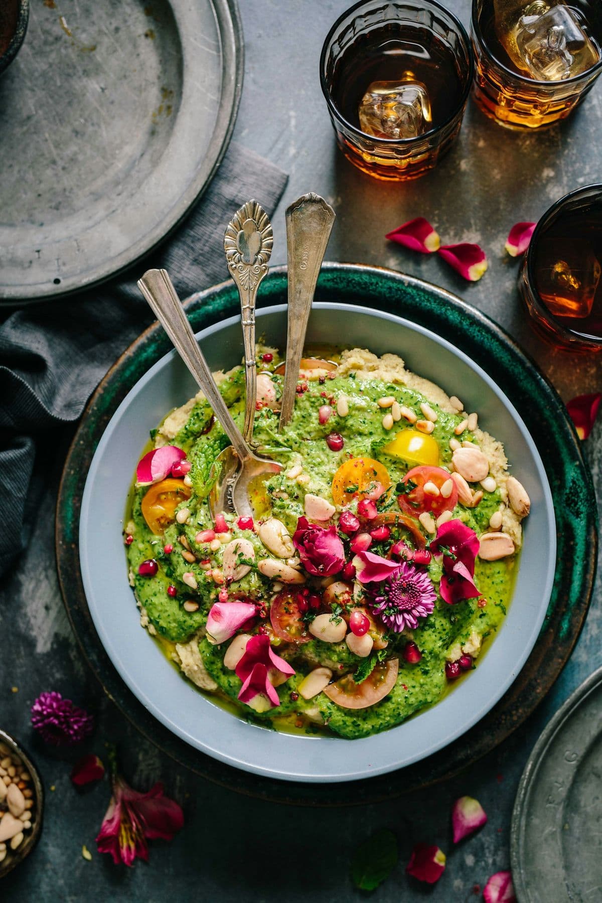 Prato de salada com flores comestíveis sobre mesa escura